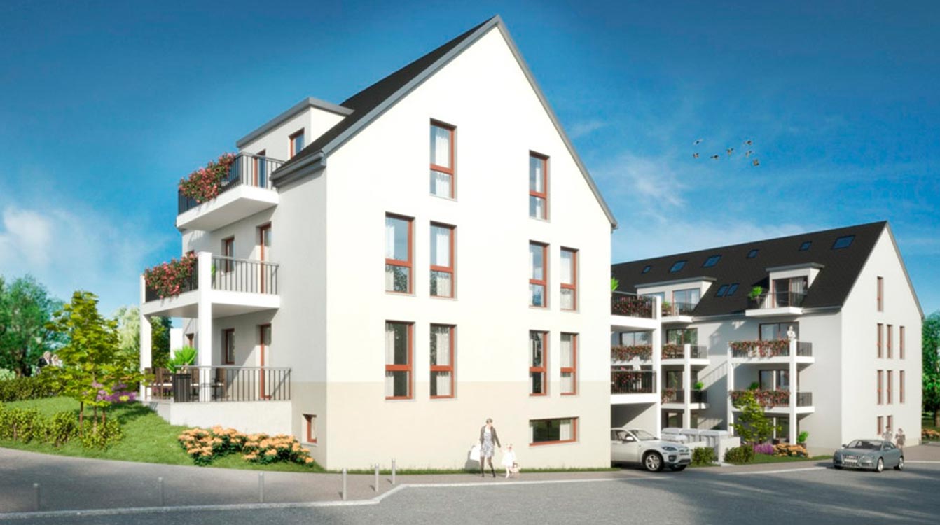 Moderne Wohnanlage mit heller Fassade, großen Fenstern und Balkonen, eingebettet in eine grüne Umgebung mit Bäumen und gepflegten Außenanlagen.